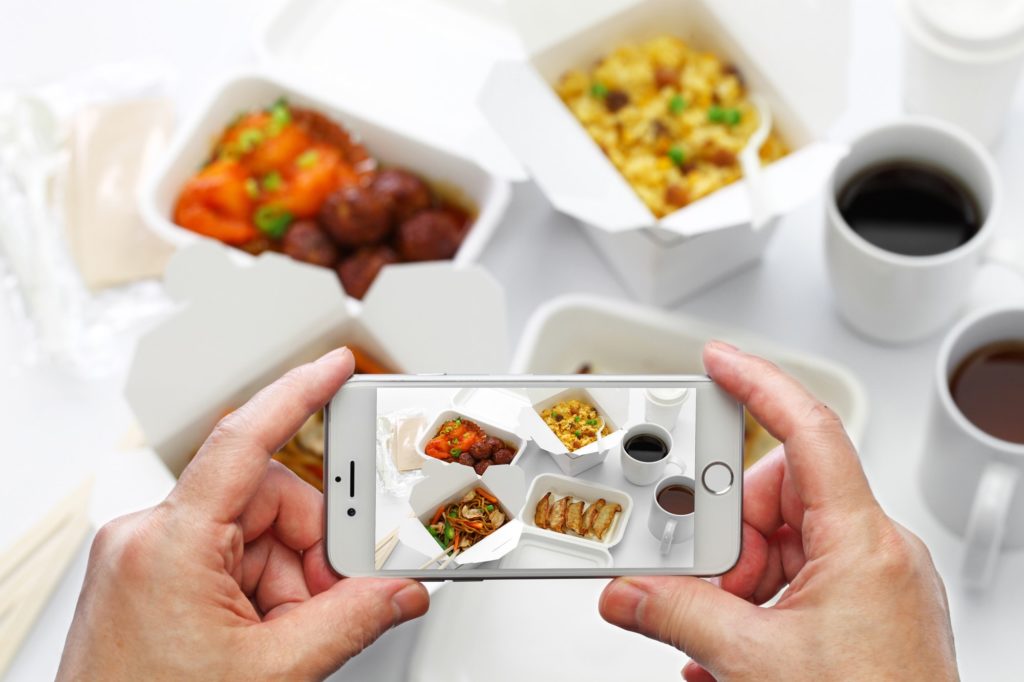 taking a photo of chinese take out food with smartphone