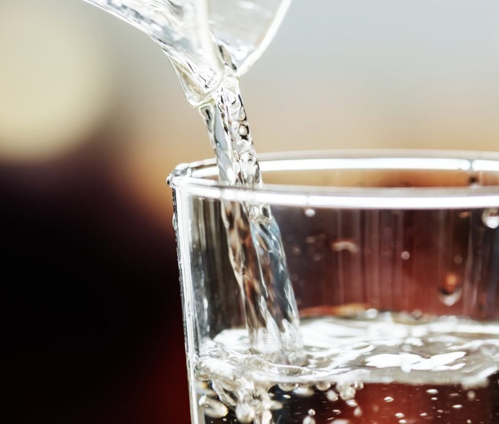 Macro shot of pouring water into a glass
